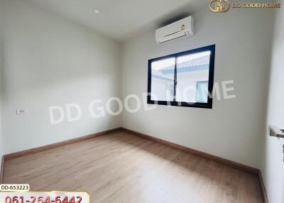 Modern empty bedroom with wooden floor, window, and air conditioner