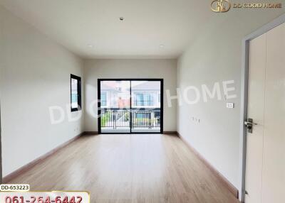 Spacious living room with large windows and wooden floors