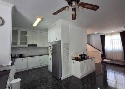 Modern kitchen with dark tiled floors and white cabinetry