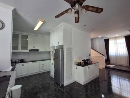 Modern kitchen with dark tiled floors and white cabinetry