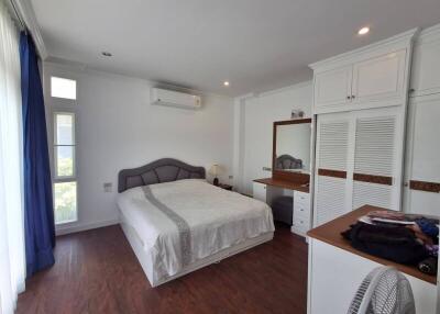 Spacious bedroom with bed, dresser, and air conditioning