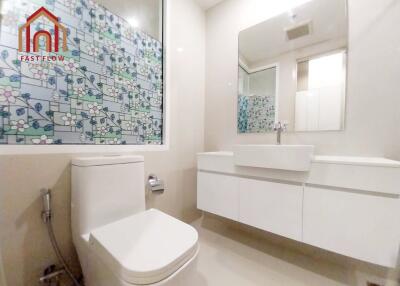 Modern bathroom with tiled wall and white fixtures