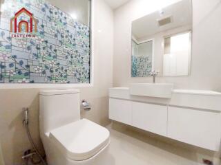 Modern bathroom with tiled wall and white fixtures