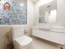 Modern bathroom with tiled wall and white fixtures