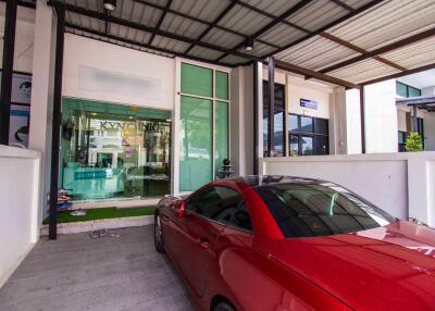 Covered parking area with a red car