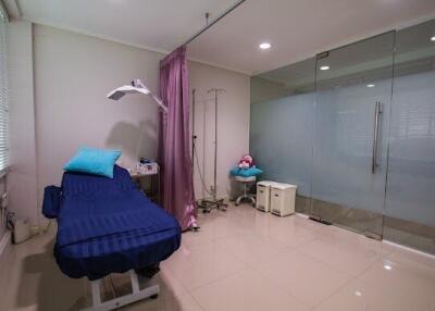 Medical office with examination bed and glass partition