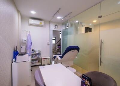 Small clinic room with a comfortable chair, equipment, and glass partition