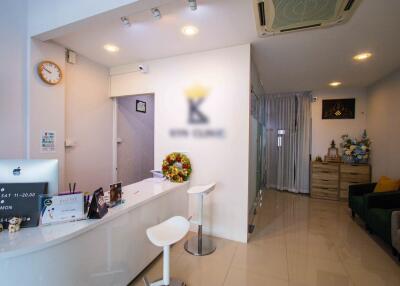 Reception area with a desk, two stools, and decorations