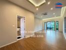 Spacious living room with wooden flooring, modern lighting, and a balcony access