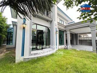 Modern residential building exterior with green lawn