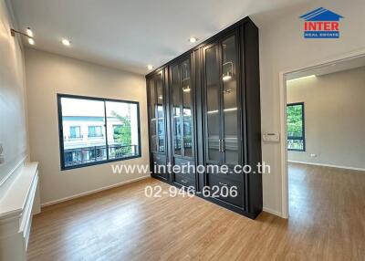 Spacious bedroom with large windows and built-in wardrobe