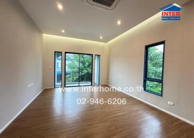 Spacious living room with wooden flooring and large windows