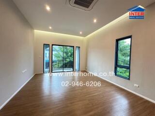 Spacious living room with wooden flooring and large windows