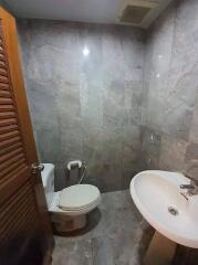 A compact bathroom with a toilet and a sink.