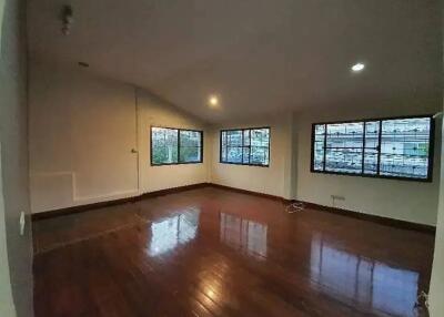 Spacious empty main living area with hardwood floors and large windows