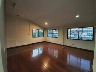 Spacious empty main living area with hardwood floors and large windows