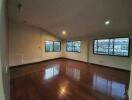 Spacious empty main living area with hardwood floors and large windows