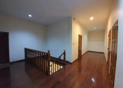 Spacious hallway with wooden flooring and railing