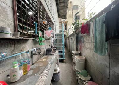 Outdoor laundry area with washing supplies and drying clothes