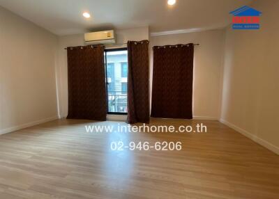 Spacious living room with wooden floor and large window