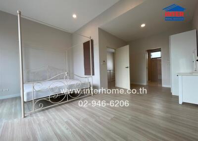 Spacious bedroom with hardwood floors and bed frame