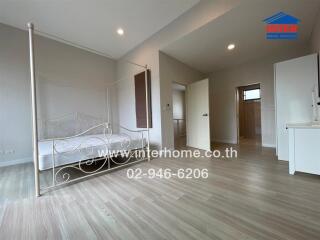 Spacious bedroom with hardwood floors and bed frame