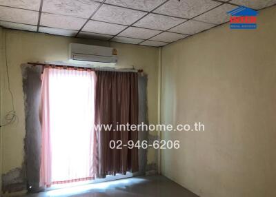 Bedroom with an air conditioner and curtain-covered window