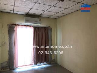 Bedroom with an air conditioner and curtain-covered window