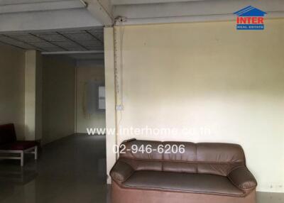 Living room with brown sofa and visible hallway