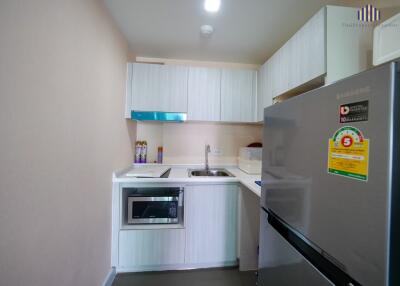 Modern kitchen with microwave, sink, and refrigerator