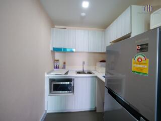 Modern kitchen with microwave, sink, and refrigerator