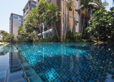 Building with a pool and lush greenery