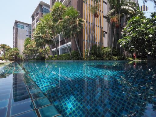 Building with a pool and lush greenery