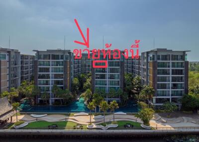 Aerial view of a modern apartment complex with landscaped gardens and a pool