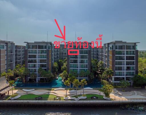 Aerial view of a modern apartment complex with landscaped gardens and a pool