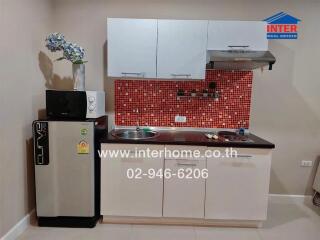 Modern kitchen with red tile backsplash and stainless steel appliances