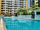 Outdoor swimming pool in front of modern apartment building