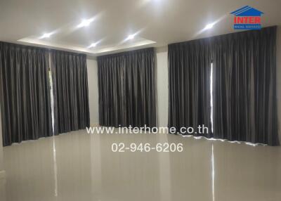 Spacious living room with glossy floors and black curtains