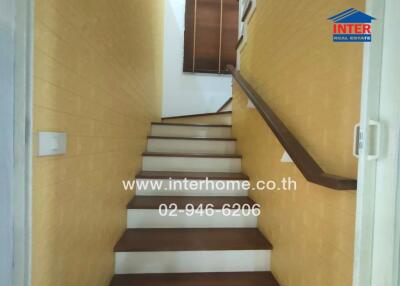 Indoor staircase with wooden steps and yellow walls