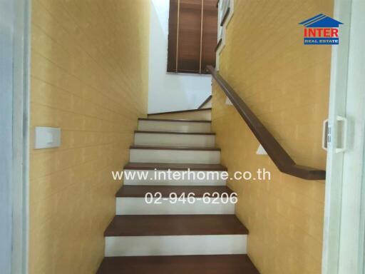 Indoor staircase with wooden steps and yellow walls