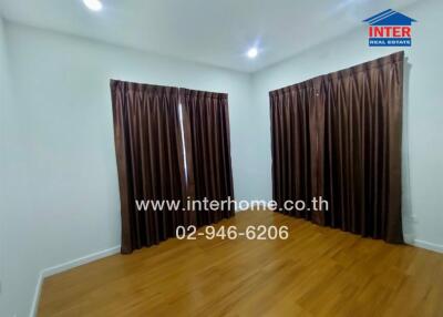 Bedroom with wooden flooring and brown curtains