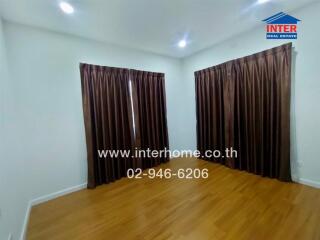 Bedroom with wooden flooring and brown curtains