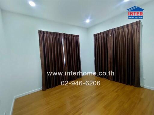 Bedroom with wooden flooring and brown curtains