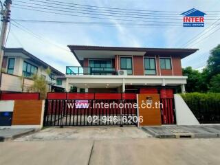 Two-story residential house with gated driveway