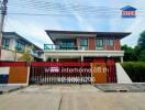 Two-story residential house with gated driveway