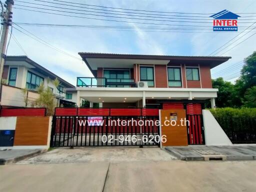 Two-story residential house with gated driveway