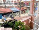 View from the balcony overlooking neighborhood houses with potted plants and an air conditioning unit seen on the side