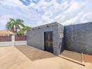 Modern outdoor shower area with black stone wall