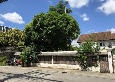 Front view of the house with a garden and trees