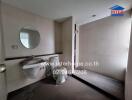 Modern bathroom with a round mirror, sink, and walk-in shower